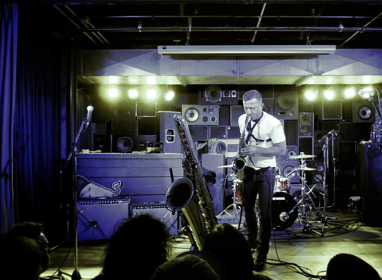 A Sled Island stage in Calgary with a saxophonist performing.